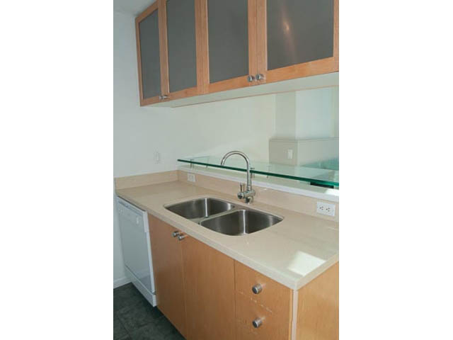 Bright kitchen with light countertops and wooden cabinets, featuring a modern sink setup. - 1406 - 1003 Burnaby Street, Vancouver Downtown