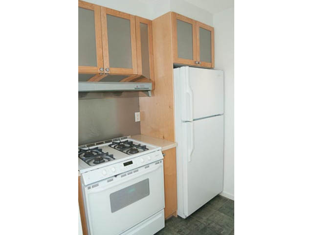 Bright kitchen with white appliances and wooden cabinets, clean and ready for move-in. - 1406 - 1003 Burnaby Street, Vancouver Downtown