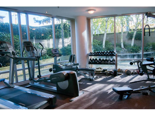 Bright gym with large windows, exercise equipment, and outdoor view. - 1406 - 1003 Burnaby Street, Vancouver Downtown