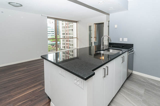 Bright kitchen with black granite countertops, hardwood floors, and a city view. - 505 - 822 Homer Street, Vancouver Downtown