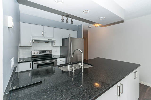Furnished kitchen with granite countertops and stainless steel appliances. - 505 - 822 Homer Street, Vancouver Downtown
