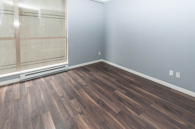 Den with hardwood floors and large window, showcasing a city view. - 505 - 822 Homer Street, Vancouver Downtown