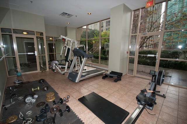 Bright fitness room with cardio machines and city view windows. - 505 - 822 Homer Street, Vancouver Downtown