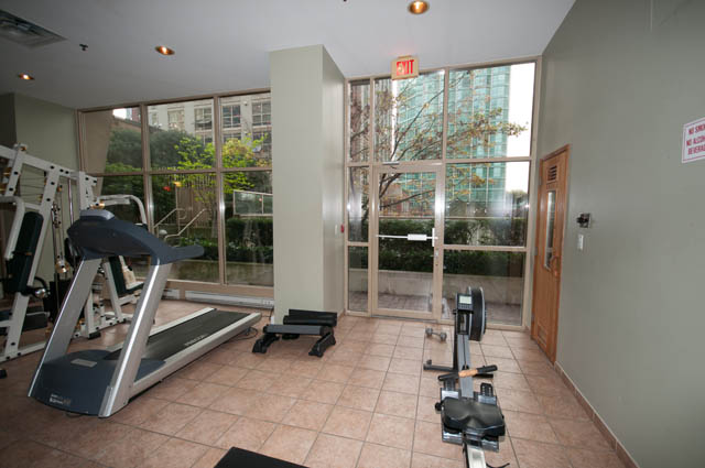 Bright and spacious gym with large windows, city view, and modern equipment. - 505 - 822 Homer Street, Vancouver Downtown