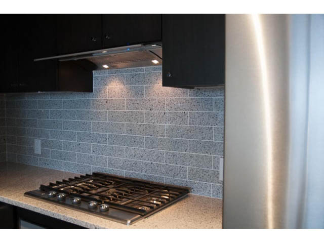 Bright kitchen with granite countertops and modern backsplash, stainless steel range hood. - 407-150 West 15th Street, North Vancouver