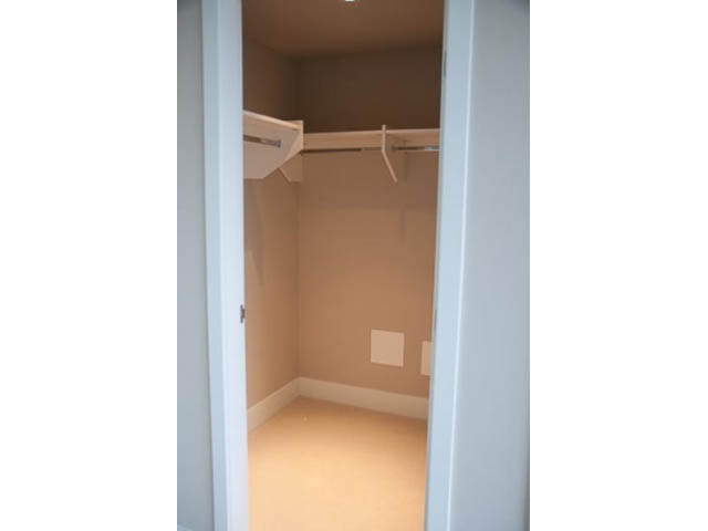 Bright walk-in closet with white walls and a wooden floor. - 407-150 West 15th Street, North Vancouver