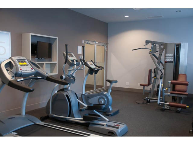Bright gym with treadmills and weight machines, modern equipment setup. - 407-150 West 15th Street, North Vancouver