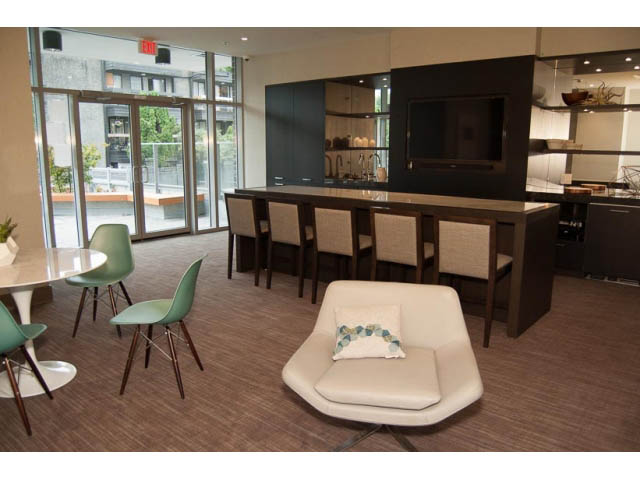 Furnished living room with modern furniture, large windows, and a city view. - 407-150 West 15th Street, North Vancouver