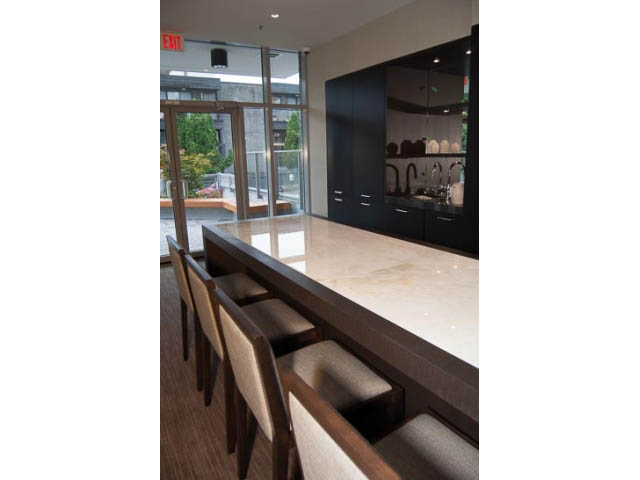 Furnished dining area with modern black cabinetry and city view through large windows. - 407-150 West 15th Street, North Vancouver
