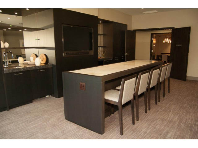 Furnished dining area with modern dark wood cabinets and a long table. - 407-150 West 15th Street, North Vancouver