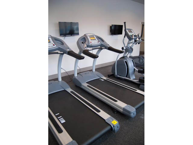 Fitness room with treadmills and elliptical, modern design. - 407-150 West 15th Street, North Vancouver
