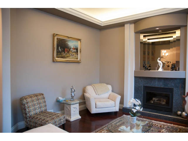 Furnished living room with hardwood floors, fireplace, and artwork on wall. - 4287 Madeley Rd, North Vancouver