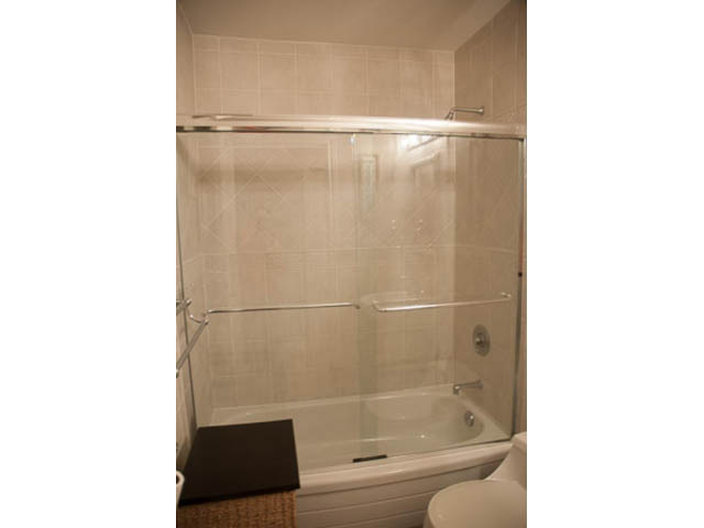 Furnished bathroom with glass shower and bathtub, modern design. - 4287 Madeley Rd, North Vancouver