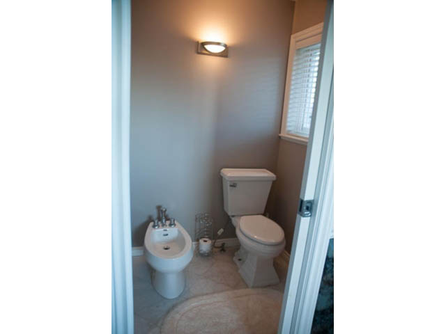 Bright bathroom with white fixtures and a window. - 4287 Madeley Rd, North Vancouver