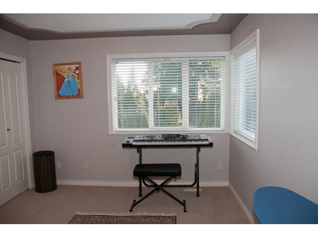 Bright music room with keyboard, bench, and large bay window. - 4287 Madeley Rd, North Vancouver