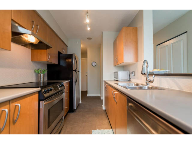 Bright kitchen with modern stainless steel appliances and light wood cabinets. - 1801 - 1295 Richards Street, Vancouver Downtown