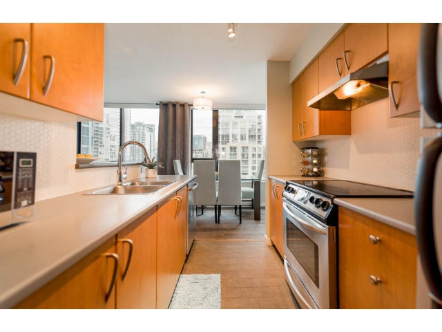 Bright kitchen with modern appliances, hardwood floors, and city view. - 1801 - 1295 Richards Street, Vancouver Downtown