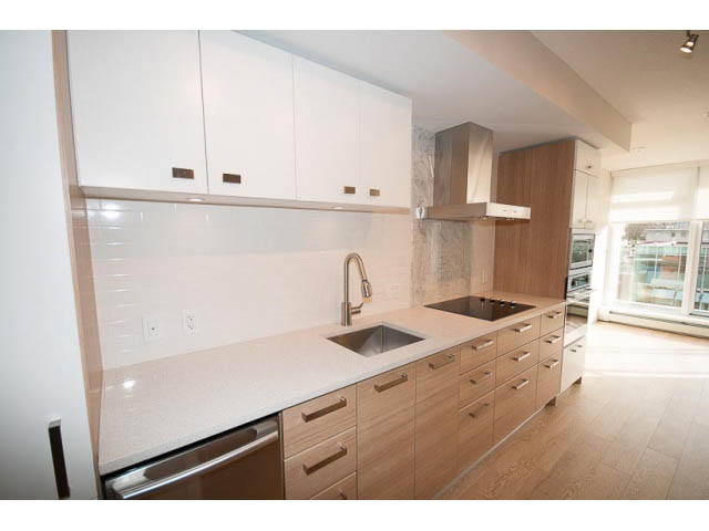 Bright kitchen with white cabinetry, granite countertops, hardwood floors, and a city view. - 305-1783 Manitoba Street, Vancouver West Side
