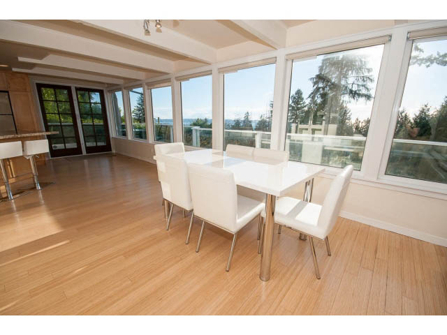 Bright dining room with hardwood floors, large windows, and a city view. - 2720 Rosebery Avenue, West Vancouver