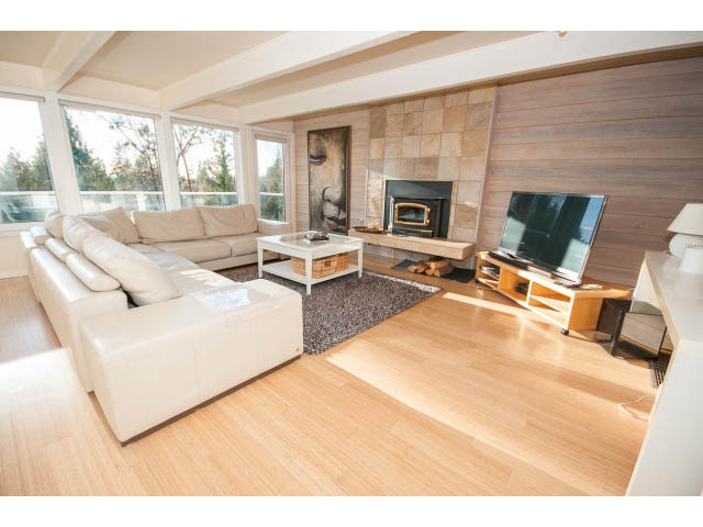 Spacious living room with hardwood floors, modern furniture, and a fireplace. - 2720 Rosebery Avenue, West Vancouver