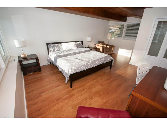 Furnished bedroom with hardwood floors, white walls, and a wooden ceiling. - 2720 Rosebery Avenue, West Vancouver