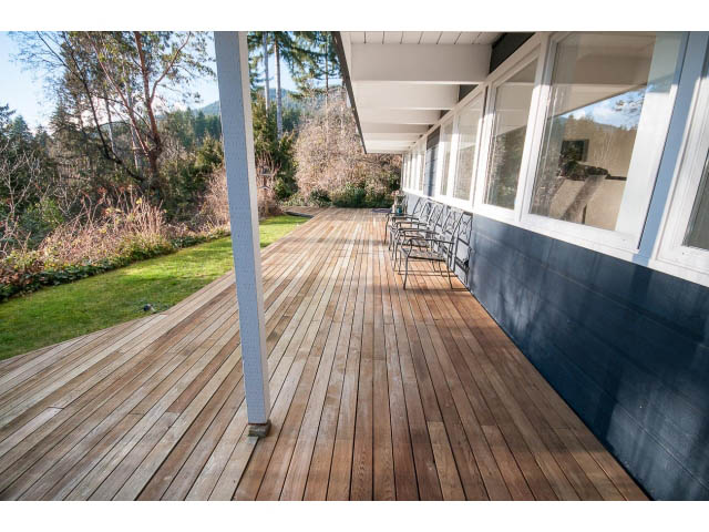 Furnished deck with wooden flooring and outdoor seating, overlooking greenery and mountains. - 2720 Rosebery Avenue, West Vancouver