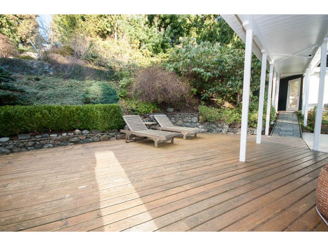 Furnished patio with wooden deck, outdoor seating, and lush greenery. - 2720 Rosebery Avenue, West Vancouver