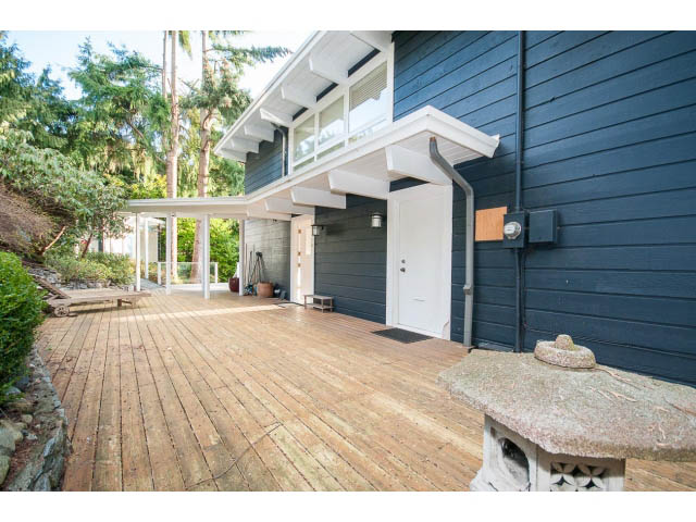 Bright deck with wooden flooring and stone fireplace, modern house design. - 2720 Rosebery Avenue, West Vancouver