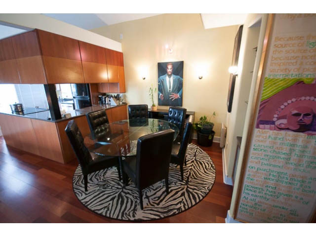 Bright kitchen with wooden cabinets, hardwood floors, and a zebra print rug. - 705 - 1263 Barclay, Vancouver Downtown