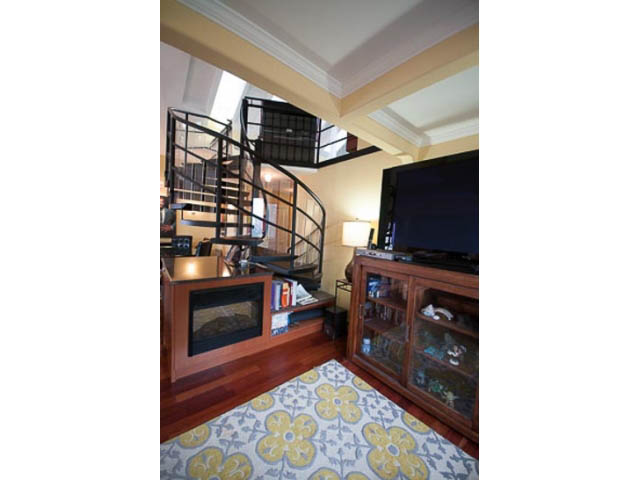 Furnished living room with spiral staircase, hardwood floors, and a patterned rug. - 705 - 1263 Barclay, Vancouver Downtown