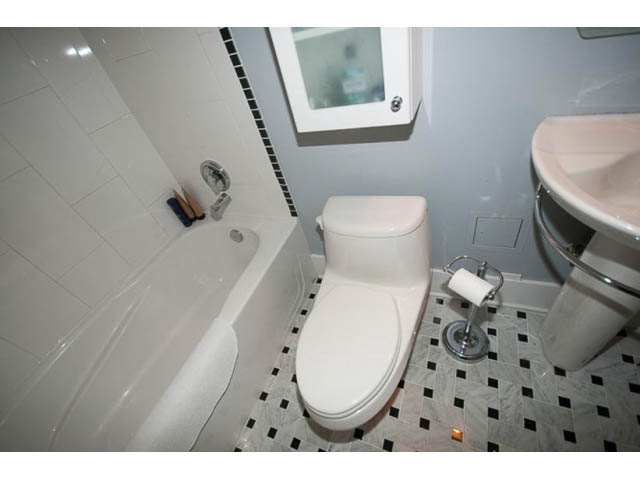 Bathroom with white fixtures, black and white tiled floor, and a bathtub. - 705 - 1263 Barclay, Vancouver Downtown