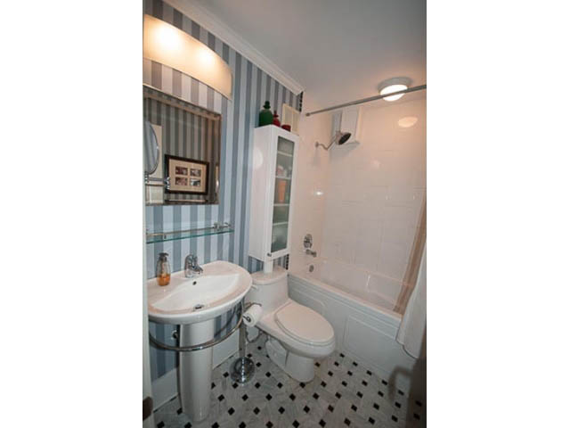 Bright bathroom with white fixtures and black-and-white checkered floor tiles. - 705 - 1263 Barclay, Vancouver Downtown