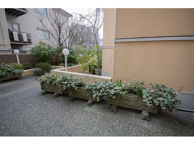 Furnished patio with stone benches and greenery, adjacent to building wall. - 705 - 1263 Barclay, Vancouver Downtown