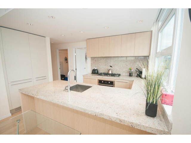 Bright kitchen with light wood cabinets, granite countertops, and a city view. - 1707 - 1351 Continental St, Vancouver Downtown