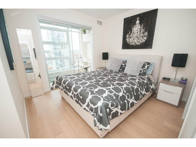 Spacious bedroom with hardwood floors, city view, and modern decor. - 1707 - 1351 Continental St, Vancouver Downtown