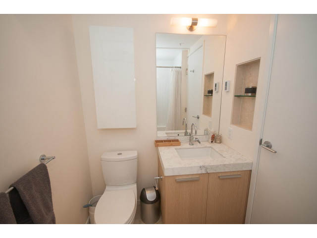 Furnished bathroom with white countertops and wooden cabinets. - 1707 - 1351 Continental St, Vancouver Downtown