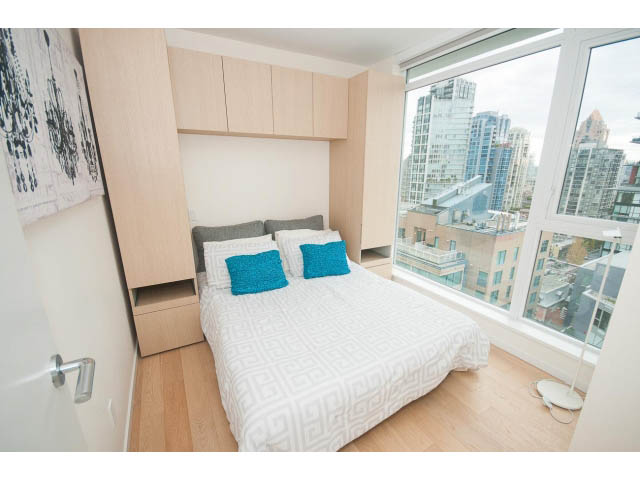 Bright bedroom with hardwood floors, city view, and modern furnishings. - 1707 - 1351 Continental St, Vancouver Downtown
