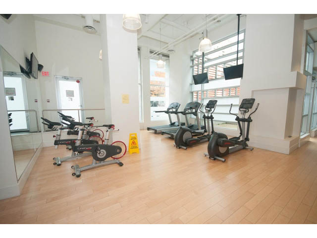 Spacious fitness room with hardwood floors and exercise equipment. - 1707 - 1351 Continental St, Vancouver Downtown