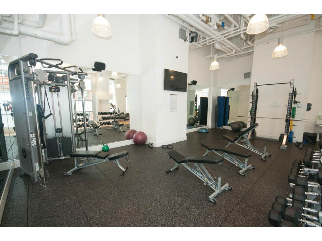 Bright and spacious gym with various workout equipment and mirrors. - 1707 - 1351 Continental St, Vancouver Downtown