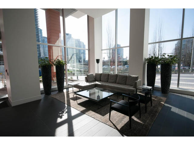 Bright living room with large windows, city view, modern furniture, and natural light. - 1707 - 1351 Continental St, Vancouver Downtown