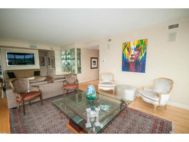 Furnished living room with hardwood floors, glass coffee table, and colorful artwork on the wall. - 1102 - 1777  Bayshore Drive, Vancouver Downtown