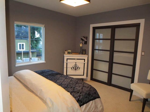Spacious bedroom with large window, modern sliding doors, and cozy bedding. - 2158 West 3rd Ave, Vancouver West Side