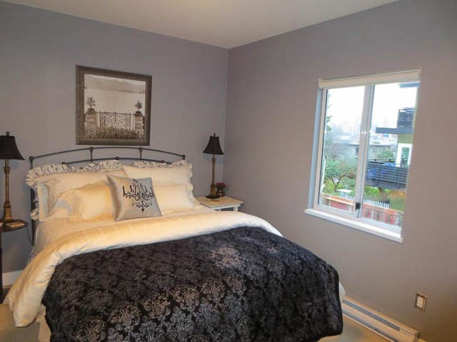 Bright bedroom with large window, city view, and neatly made bed. - 2158 West 3rd Ave, Vancouver West Side