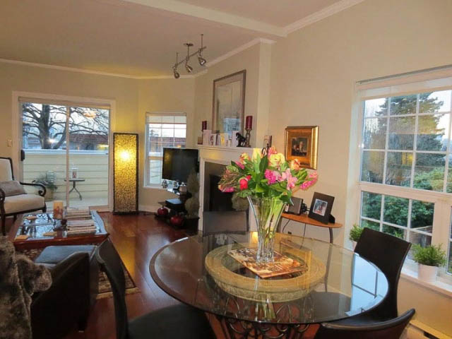 Bright dining area with glass table, floral centerpiece, and large windows. - 2158 West 3rd Ave, Vancouver West Side