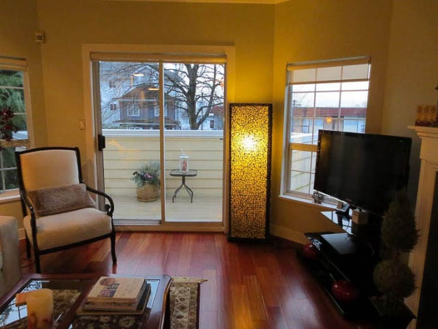 Living room with hardwood floors, large windows, and a flat-screen TV. - 2158 West 3rd Ave, Vancouver West Side