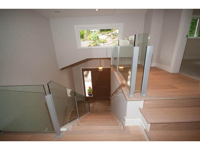 Bright staircase with glass railings leading to a sunlit upper level. - 905 Braeside St, West Vancouver