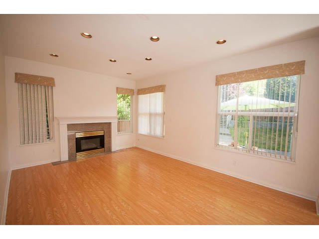 Bright living room with hardwood floors, large windows, and a fireplace. - 1559 Mathers Ave, West Vancouver