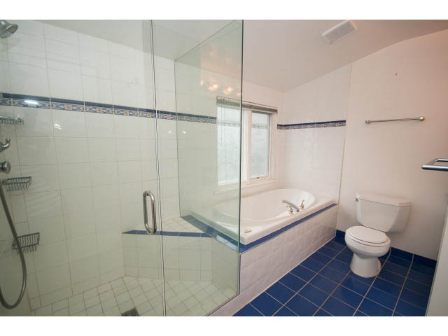 Bright bathroom with blue tile floor and glass shower enclosure. - 3407 West 34th Ave, Vancouver West Side
