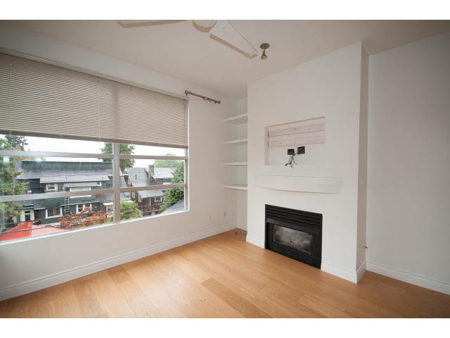 Spacious living room with hardwood floors, city view, and modern fireplace. - 409 - 3023 West 4th Ave., Vancouver West Side