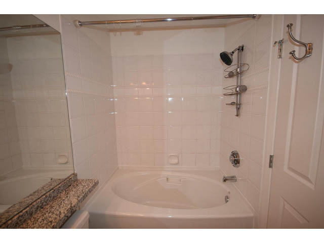 Bathroom with white tiles, granite countertop, and modern fixtures. - 409 - 3023 West 4th Ave., Vancouver West Side